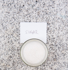 Sugar in a glass bottle on granite surface