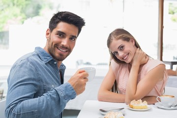 Obraz na płótnie Canvas Smiling couple having coffee at coffee shop