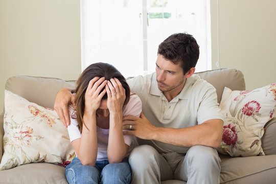 Man Consoling A Sad Woman In Living Room