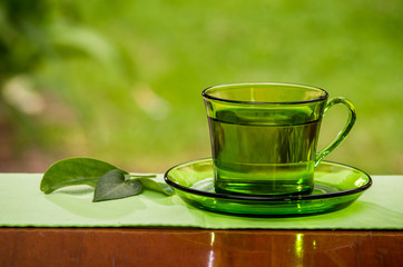 Tea cup with fresh lemons, closeup photo
