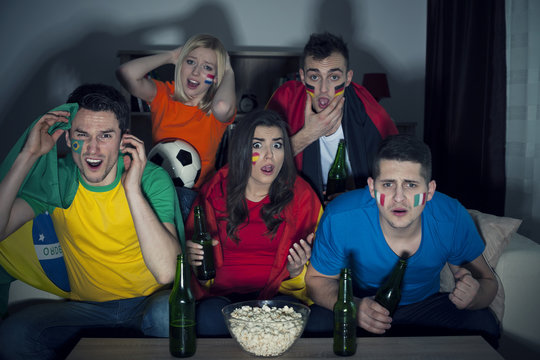 Shocked friends watching soccer match on TV