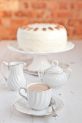 Cup of coffee with hummingbird cake on background