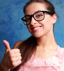 Happy student girl showing thumb up sing. Closeup portrait