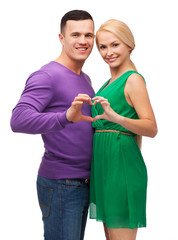 smiling couple showing heart with hands