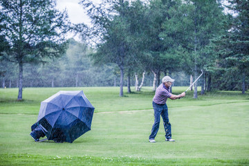 Golfer on a Rainy Day Swigning in the Fairway