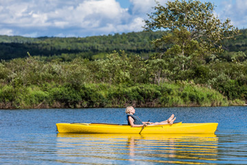 Calm River and Woman relaxing in a Kayak