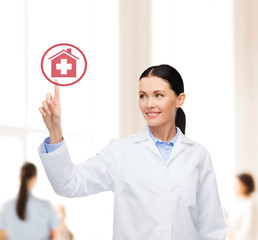 smiling female doctor pointing to hospital sign