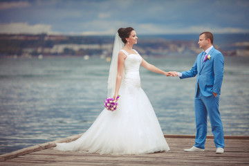 Bride and groom at wedding day kiss in park, retro grain