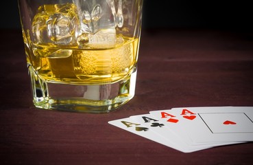poker playing cards near wiskey glass