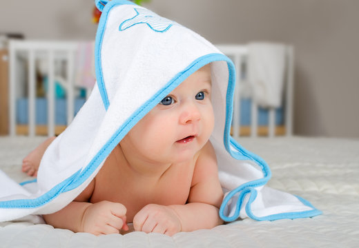 Cute baby boy in a hooded towel after bath