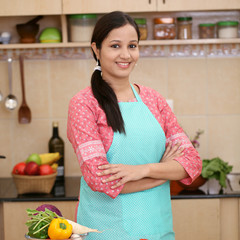 Smiling young Indian woman with kitchen apron