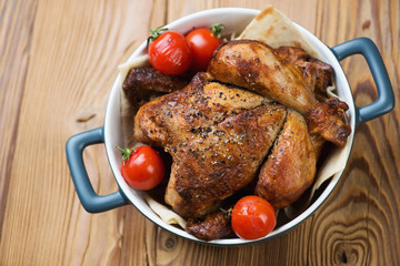 Whole baked spicy chicken, wooden background, above view