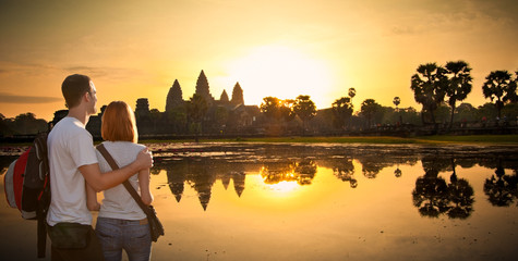 Couple at Angkor Wat temple in sunrice, Cambodia. - obrazy, fototapety, plakaty