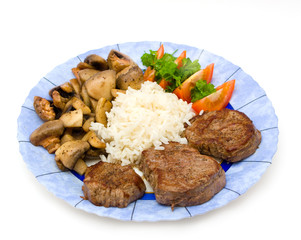 Steak on a plate with fried mushrooms, rice and tomato
