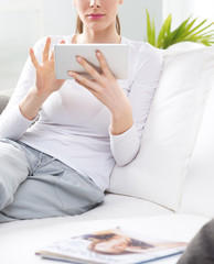 Woman relaxing on sofa with tablet