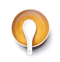 Orange plate and china spoon on white background