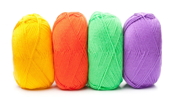 stack of yarn skeins in red, yellow, green, purple colors on whi