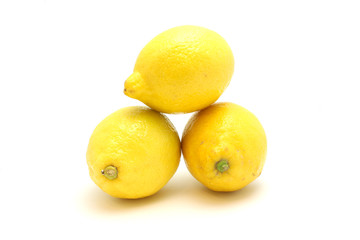 Bright lemons on a white background lie on each other