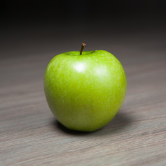 granny smith green apple against wooden background