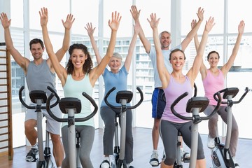 Happy people working out at spinning class