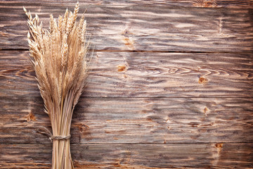 Ears of wheat on old wooden table.