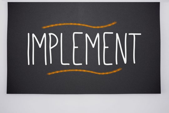 Implement written on big blackboard