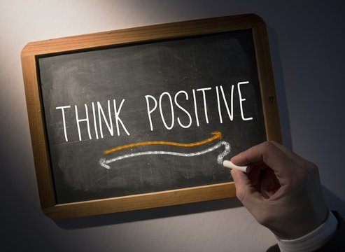 Hand writing Think positive on chalkboard