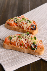 Delicious bruschetta with tomatoes on table close-up