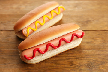 Tasty hot dogs on wooden table