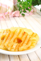 Juicy grilled pineapple on plate on table close-up