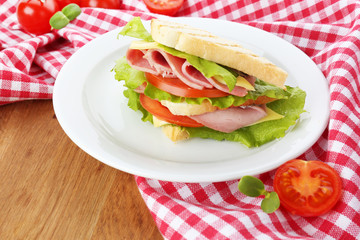 Tasty sandwich with ham on wooden table