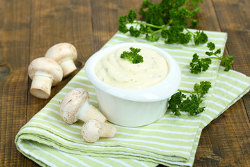 Delicate mushroom sauce in bowl on wooden table close-up