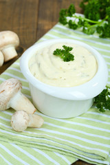 Delicate mushroom sauce in bowl on wooden table close-up