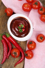 Tomato sauce in bowl on wooden table close-up