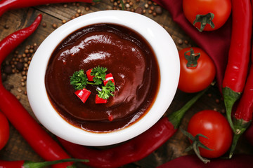 Tomato sauce in bowl on wooden table close-up