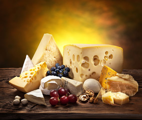Different types of cheese over old wooden table.