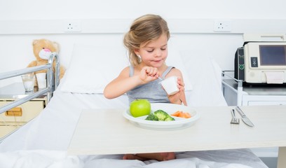 Obraz na płótnie Canvas Ill girl eating healthy food in hospital
