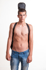 Fototapeta premium portrait of young man wearing no top with his guitar on back