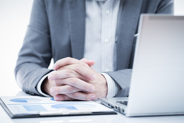 Businessman analyzing investment charts with laptop