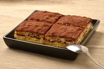 Close up of tiramisu cake with cocoa; selective focus.
