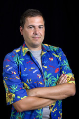 young happy man with a hawaiian shirt on black background