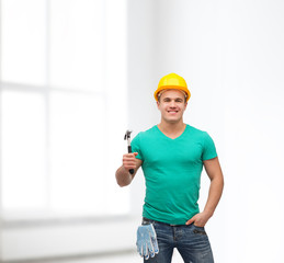 smiling manual worker in helmet with hammer