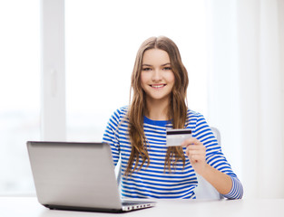 smiling teenage gitl with laptop computer at home