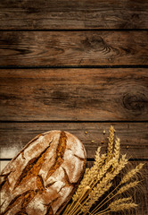 Rustic bread and wheat on vintage wood table