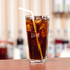 glass of cola with ice on the bar