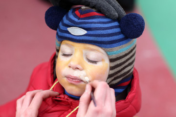 Woman painting child face