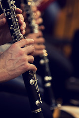 Human hands playing a clarinet closeup