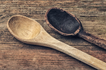 Two wooden spoons on a wooden background