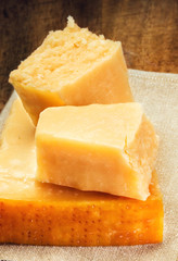 Parmesan Cheese on Wooden Background close up. Piece of Parmesan