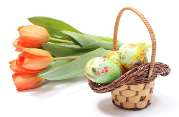 Fototapeta na wymiar Colorful Easter eggs in wicker basket and fresh tulips